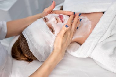 Kapalı gözlerle uzanan güzel genç bir kadın spa ameliyatı oluyor.
