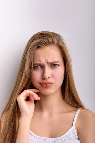 Mujer perpleja perpleja está insatisfecha con algo, mirando curioso aislado en blanco —  Fotos de Stock