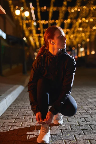 Ganska självsäker löpare kvinna i sportiga kläder förbereder sig för jogging, slips skosnören — Stockfoto