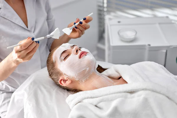 Cosmetólogo o dermatólogo cosechado confiado haciendo mascarilla facial en la oficina de cosmetología —  Fotos de Stock