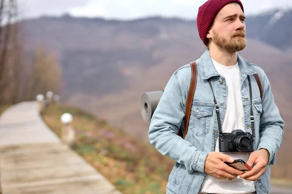 Cestovatel procházky v horách s kamerou, těší scenérie, boční pohled portrét — Stock fotografie