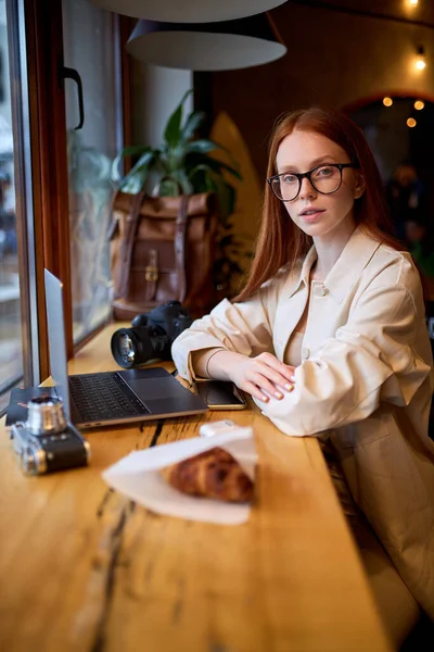 Mujer viajero serio usando ordenador portátil en la cafetería, trabajando en la cafetería. — Foto de Stock