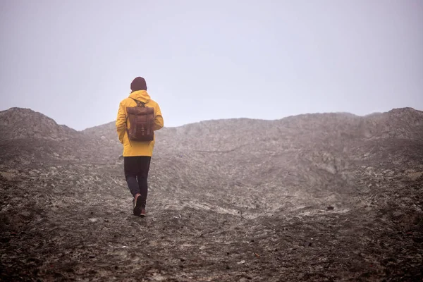 Vandrare går på toppen av berg klippa över dimmig och dimmig morgon — Stockfoto