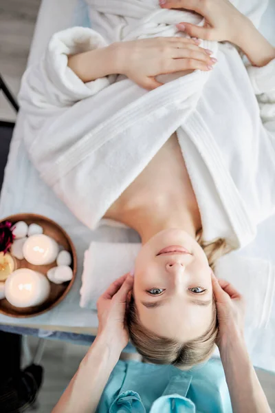 Bovenaanzicht van positieve blanke vrouw ontspannen terwijl zorgvuldige specialist masseren haar gezicht — Stockfoto