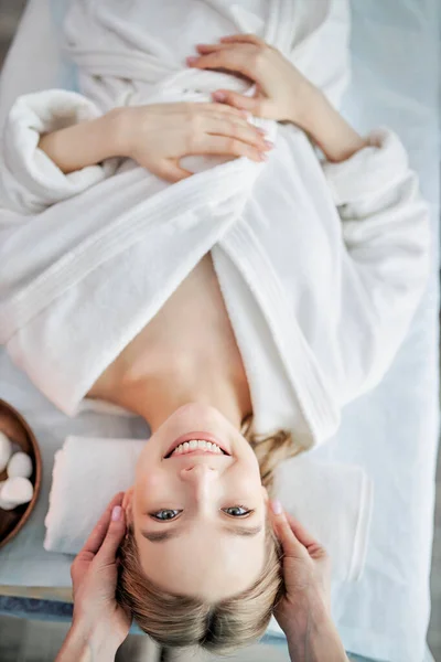 Ung kvinna njuter av massage i spa salong. Ansiktsmassage av kvinnlig massör. — Stockfoto