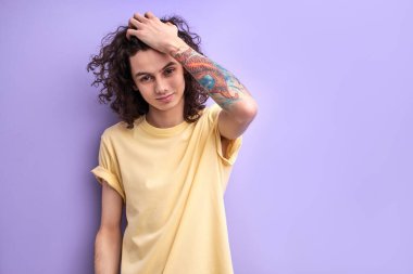 Kıvırcık siyah saçlara dokunan yakışıklı beyaz adamın portresi.