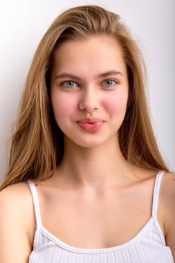 Beyaz fanilalı, zevkli beyaz kadın kameraya bakıyor.