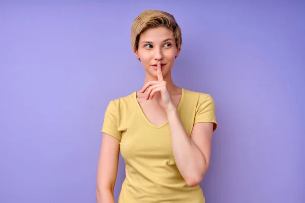 Jonge blanke vrouw die haar vinger op de mond houdt en vraagt om stil te zijn, zwijg dan. — Stockfoto
