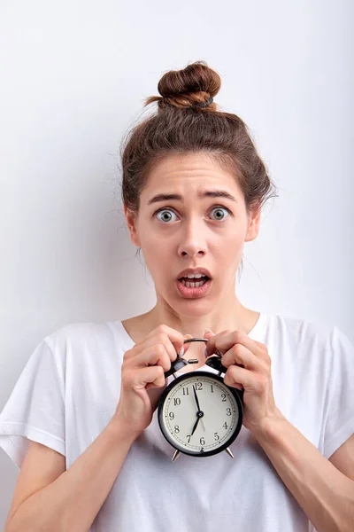 Shocked surprised woman holding alarm clocks in hands in shock, in the morning — Stock Photo, Image
