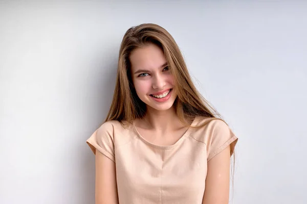 Портрет веселой очаровательной девушки на белом фоне, счастливо улыбающейся — стоковое фото