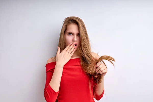 Impactado joven insatisfecho por el cabello seco con puntas abiertas, molesto, aislado en blanco — Foto de Stock