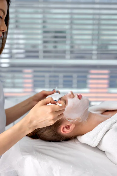 Vágott női orvos kozmetológus vagy bőrgyógyász arcmaszkot készít a kozmetikai irodában — Stock Fotó