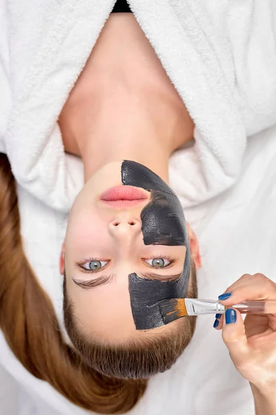 Kobieta relaks z węglem drzewnym maski twarzy, przycięte profesjonalny kosmetyk stosowania na twarz — Zdjęcie stockowe
