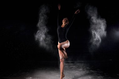 Güzel ince balerin kadın, vücut giysisi giymiş, poz veriyor.