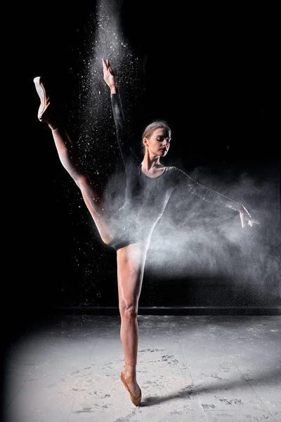 Danseuse posant gracieusement en studio avec nuage de poussière, farine. — Photo