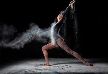 Un konseptinde dans etmek. Toz bulutu içindeki balerin kadın dansçı. Kadın dansçı portresi