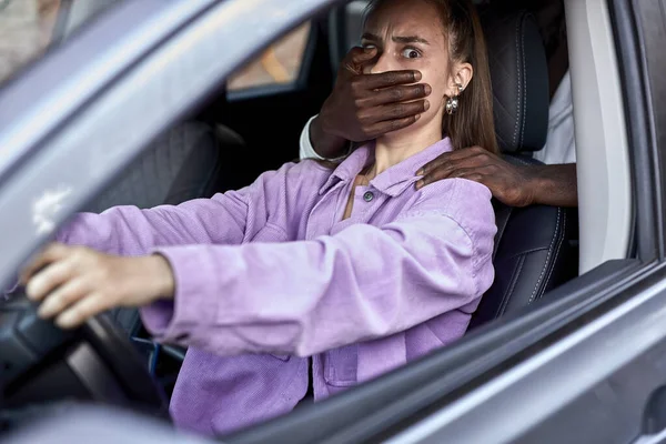 Pericoloso uomo nero thie minaccia spaventato giovane donna all'interno della macchina — Foto Stock