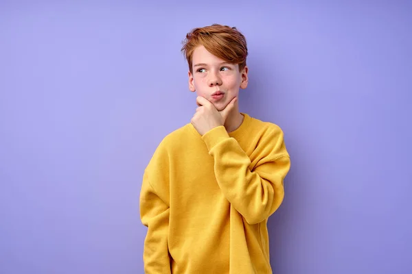 Let me think. thoughtful redhead schooler with puzzled serious expression — Stock Photo, Image