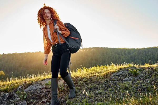 Donna rossa sognante in escursione. escursionista femminile con zaino a piedi sul sentiero di montagna. — Foto Stock