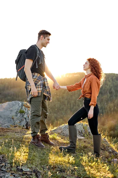日照时分站在山中的白种人年轻夫妇的侧面画像 — 图库照片