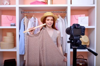 Sevimli genç kadın yeni moda etek hakkında video bloğu bölümü kaydediyor.