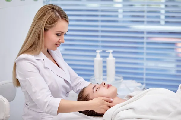 Giovane donna godendo anti invecchiamento massaggio facciale. Bella signora ottenere la cura della pelle professionale — Foto Stock