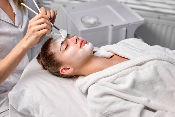 Adorable pretty woman laying on couch relaxed being treated by cosmetologist — Stock Photo, Image