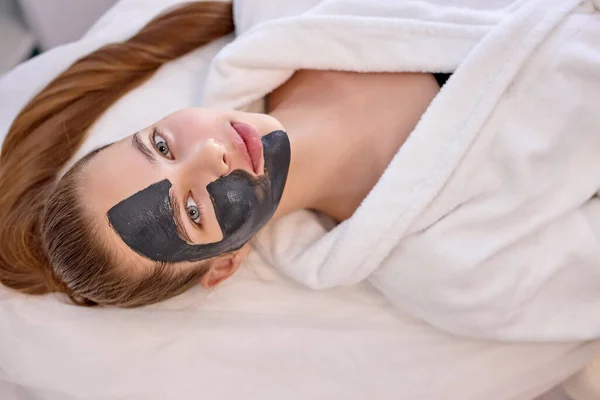 Top Zobrazit na dobře vypadající roztomilé ženy s černou obličejovou maskou na půl obličeje — Stock fotografie