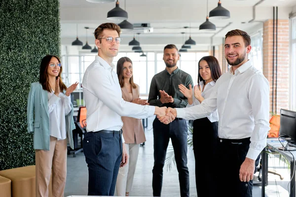 Üzletember kollégák köszöntik egymást, kezet ráznak a modern irodában. — Stock Fotó