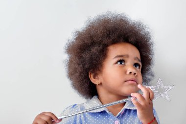 Koyu tenli tatlı kız, melez çocuk sihirli değnekle oynuyor.