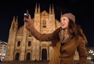 Akşam Duomo önünde fotoğraf çeken gülümseyen kadın , Milano