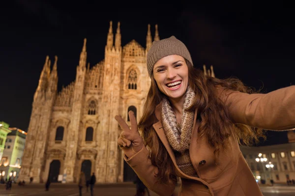 Woman showing victory gesture and taking selfie near Duomo — Stockfoto