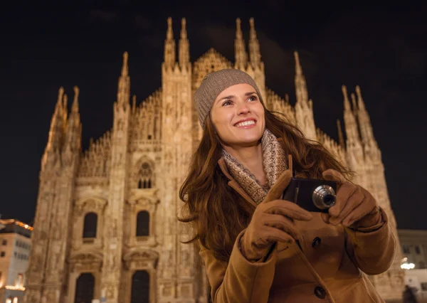 Lachende vrouw met fotocamera in de buurt van Duomo in de avond, Milaan — Stockfoto