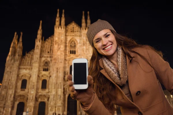 Donna sorridente che mostra il cellulare vicino al Duomo in serata, Milano — Foto Stock