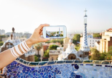 Closeup on female tourist taking photos in Park Guell, Barcelona