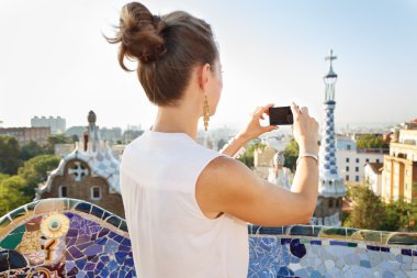 Seen from behind woman taking photo in Park Guell, Barcelona