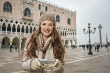 Woman tourist writing sms while standing on St. Mark's Square