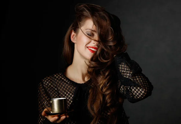 Mujer feliz con el pelo castaño ondulado largo sosteniendo taza de café —  Fotos de Stock