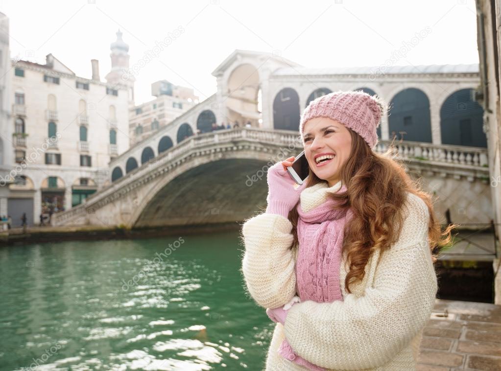 Happy woman tourist talking cell phone in front of Rialto Bridge