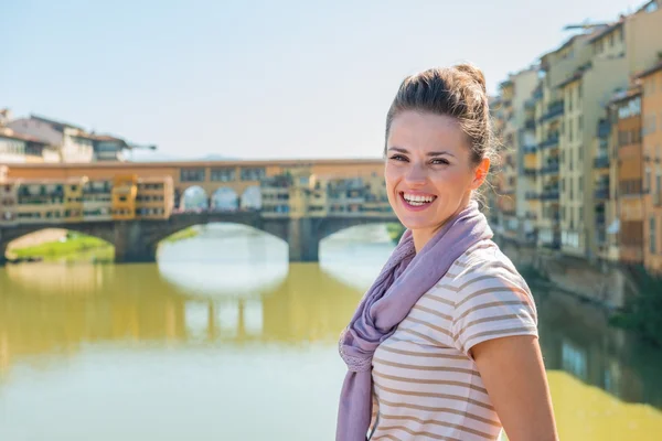 Turista sorridente em pé na ponte com vista para Ponte Vecchio — Fotografia de Stock