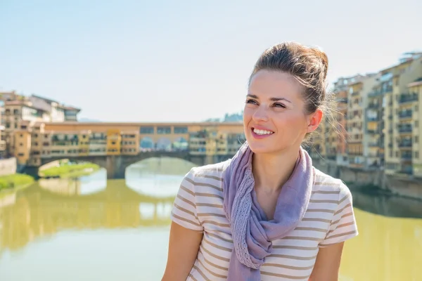 Turista sonriente parado en el puente con vistas a Ponte Vecchio —  Fotos de Stock