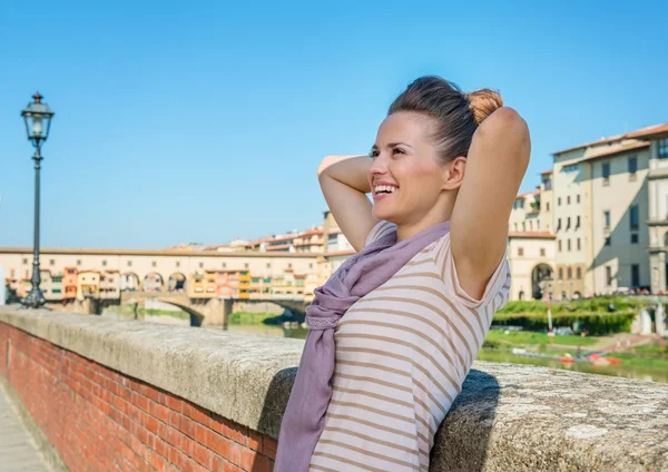 Relaxed tourist standing on embankment overlooking Ponte Vecchio — Stock Photo, Image