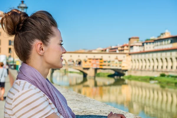 Young tourist standing on embankment overlooking Ponte Vecchio — Stockfoto