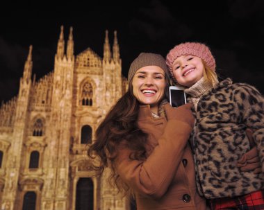 Anne ve kızı Milano'da Duomo yakınlarındaki akıllı telefon konuşuyor