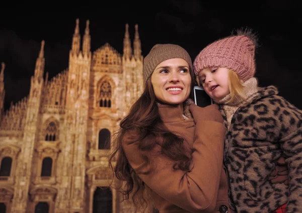 Мать и дочь разговаривают на смартфоне возле Дуомо в Милане — стоковое фото