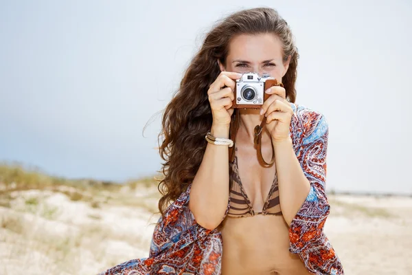 波西米亚女人怀旧照片相机在海滩上拍照 — 图库照片