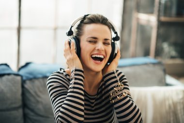 Mutlu genç kadın loft daire müzik dinleme
