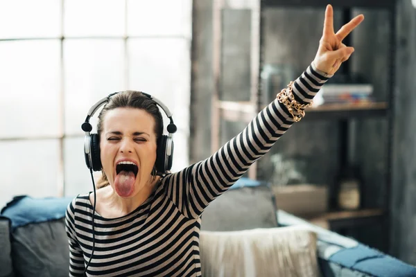 Vrolijke jonge vrouw, luisteren naar muziek in loft appartement — Stockfoto