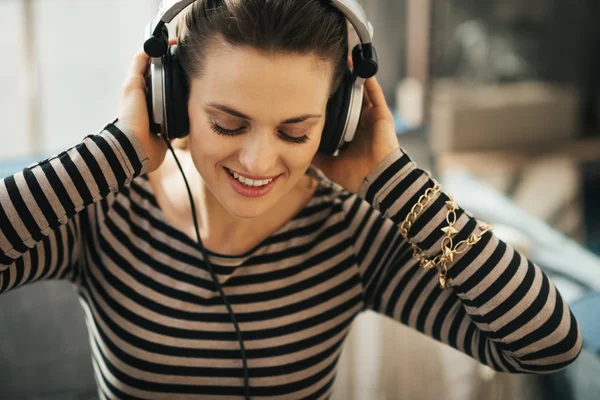 Mujer escuchando música en un apartamento tipo loft. Primer plano retrato . —  Fotos de Stock