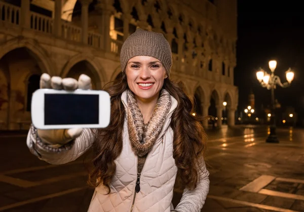 Gelukkige vrouw toerist toont smartphone op het San Marcoplein — Stockfoto